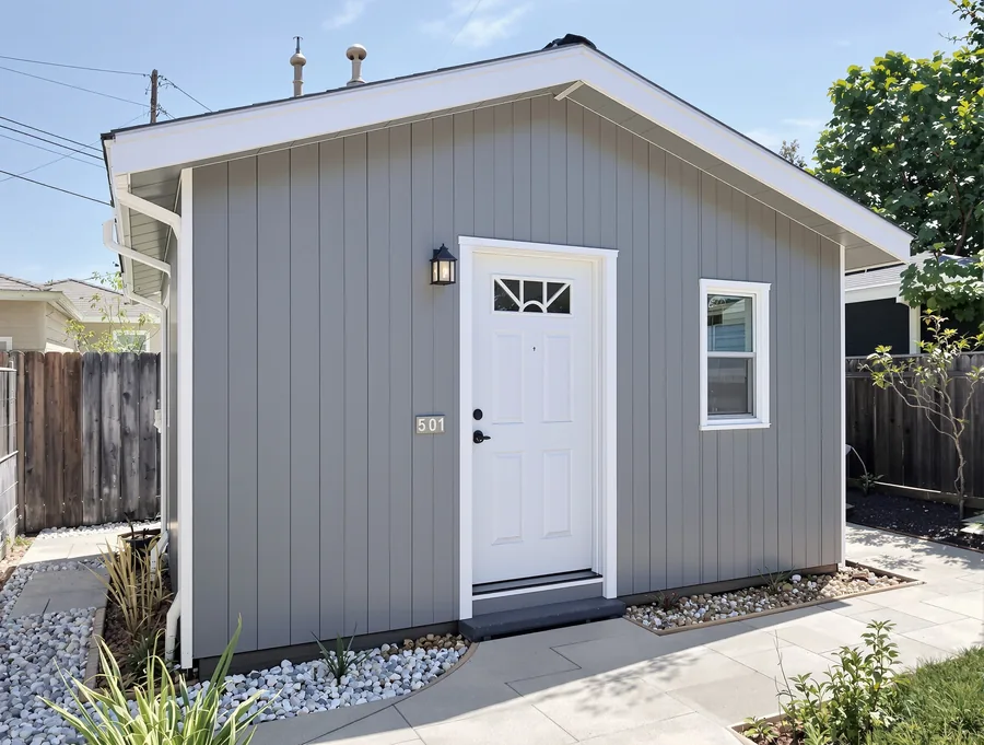 A small modern grey-sided detached ADU in a tidy California backyard
