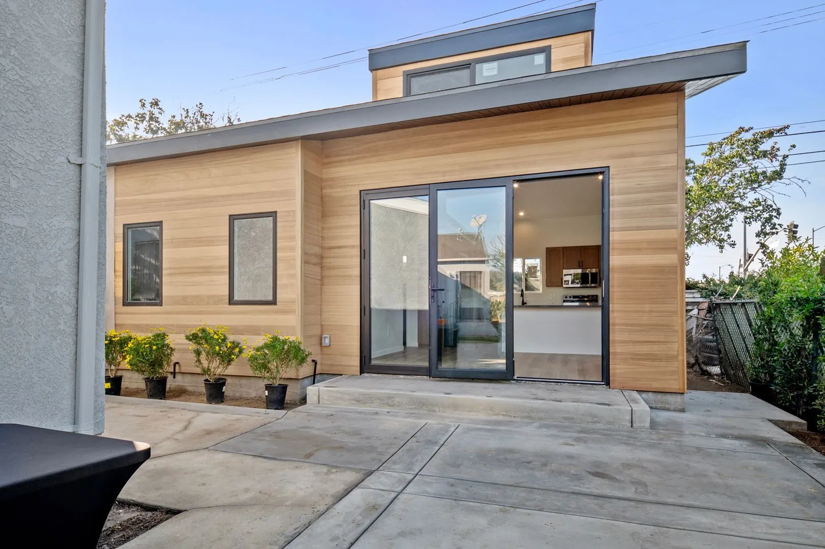 Open-concept modern detached ADU in Los Angeles with cedar wood siding and full-height sliding glass doors